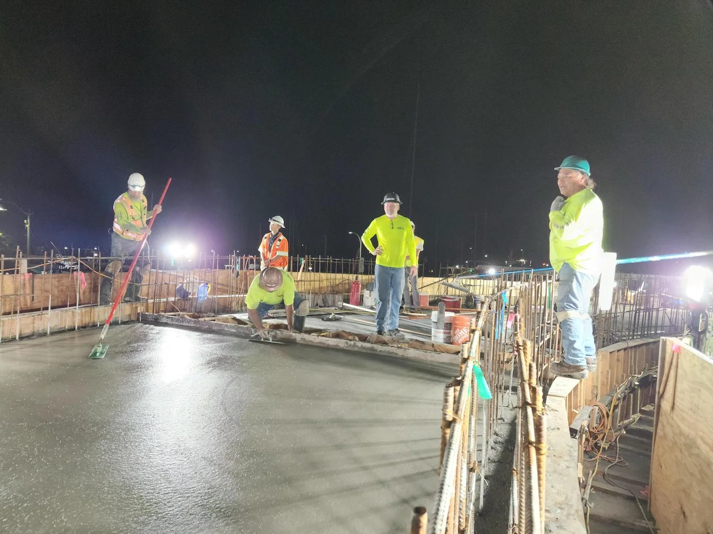 Concrete truck and MIRA crew supporting a nighttime deck pour.