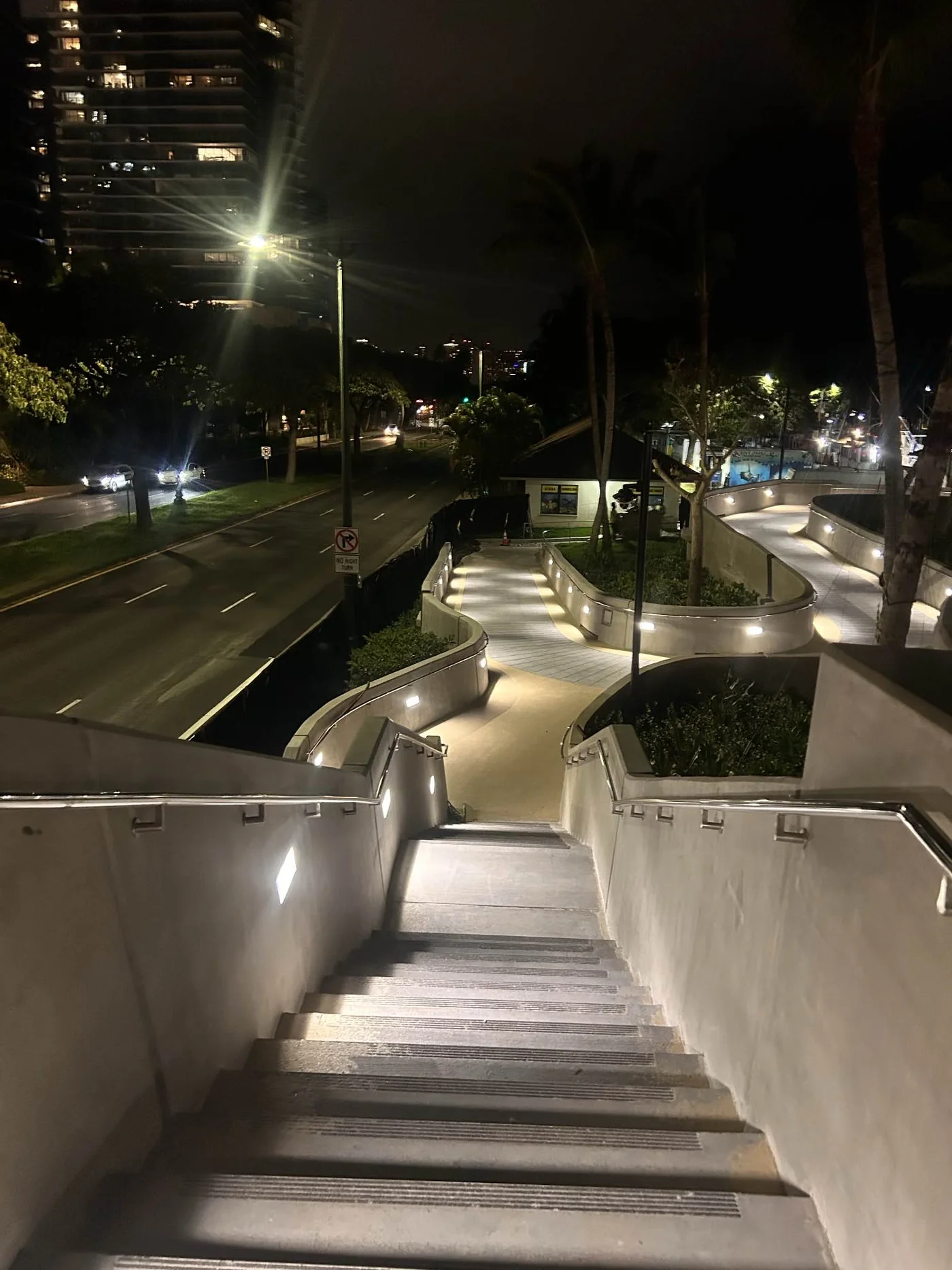 Finished elevated pedestrian walkway illuminated at night.