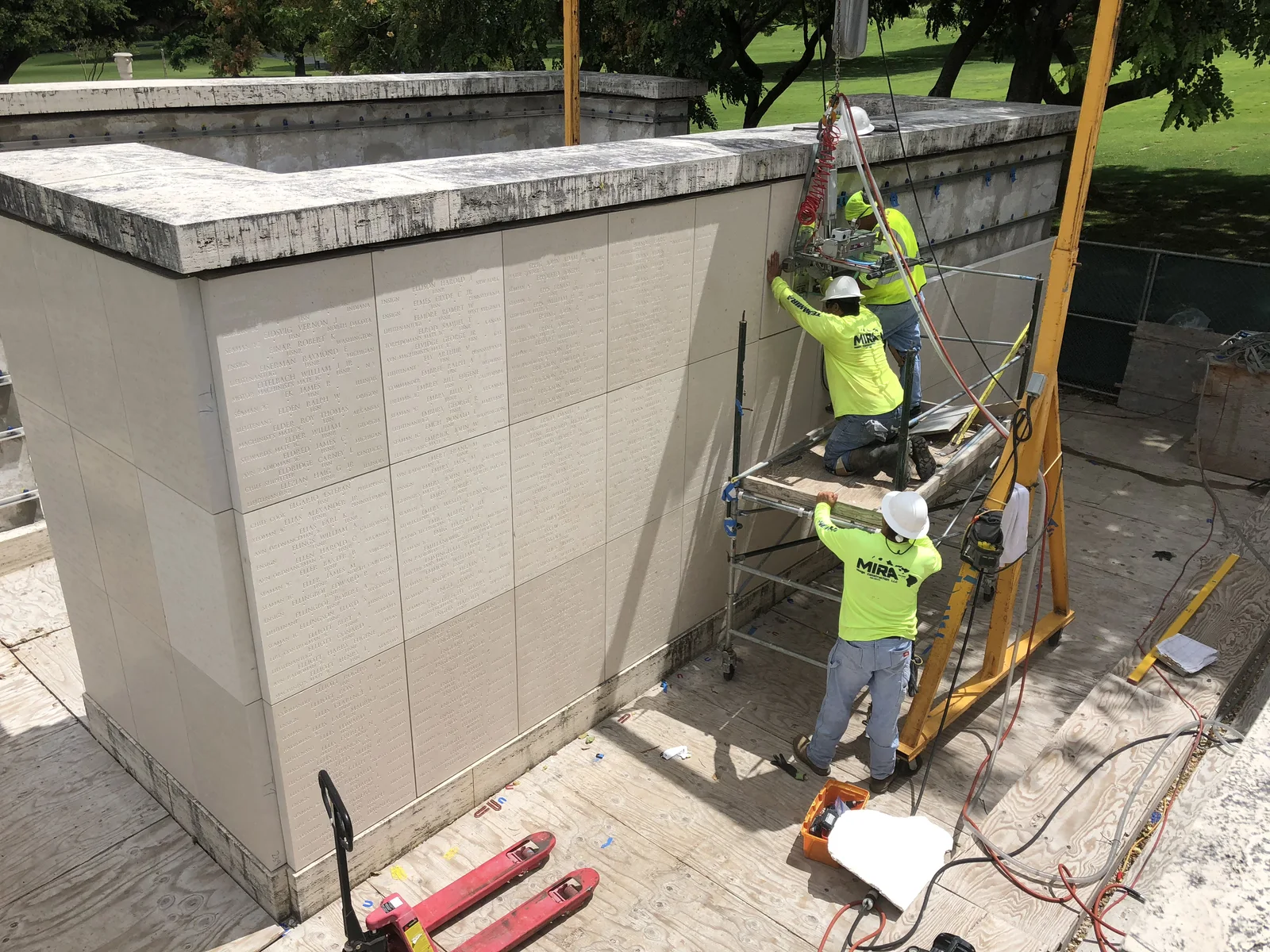 Craftworkers completing precision installation work at the memorial.